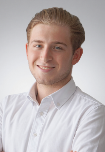 Portrait von Nick Riedel, Auszubildender von Immobilien, lächelnd im weißen Hemd vor neutralem Hintergrund.