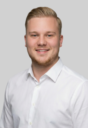 Portrait von Benedikt Zimmermann, Experte für Verkauf / Vermietung von Immobilien, lächelnd im weißen Hemd vor neutralem Hintergrund.