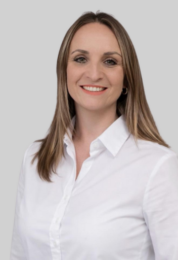 Portrait von Monika Mischko, Teamassistenz und Buchhaltung bei Zenker & Günsch Immobilien, lächelnd in weißer Bluse vor neutralem Hintergrund.